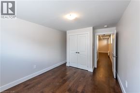 St. Catharines apartment for rent - A white door is in a hallway with wood floors.