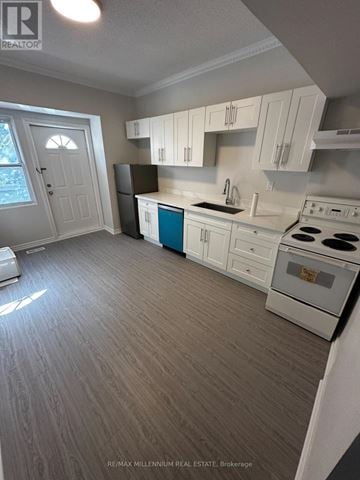 Toronto (North St. James Town) apartment for rent - A kitchen with white cabinets and a blue island.