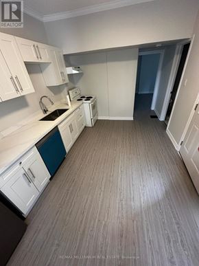 Toronto (North St. James Town) apartment for rent - A kitchen with white cabinets and a wooden floor.