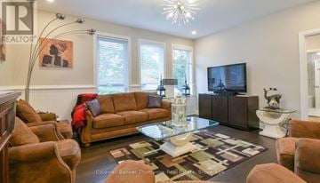 Huntsville (Chaffey) duplex for rent - A living room with a brown couch and a glass coffee table.