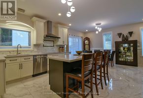 Huntsville (Chaffey) duplex for rent - A kitchen with a marble countertop and wooden chairs.