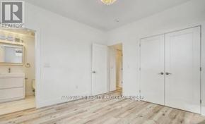 Toronto (Weston) multi-family for rent - A room with white walls and wooden flooring, featuring a white cabinet and a white sink.
