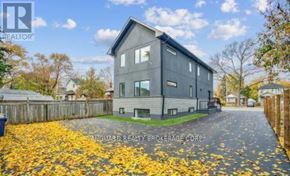 Toronto (Weston) multi-family for rent - A grey house with a fence and yellow leaves on the ground.