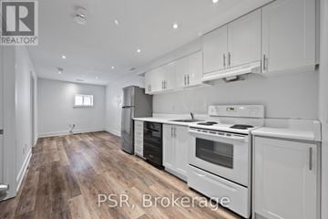 Toronto (Briar Hill-Belgravia) apartment for rent - A modern kitchen with white appliances and wooden floors.