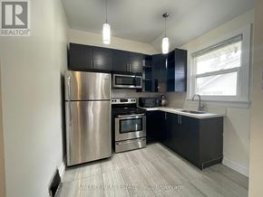 Mississauga (Mineola) multi-family for rent - A kitchen with a stainless steel refrigerator, microwave, oven, and sink.