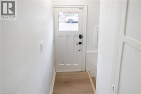 Hamilton apartment for rent - A white door with a black handle is in the middle of a hallway.