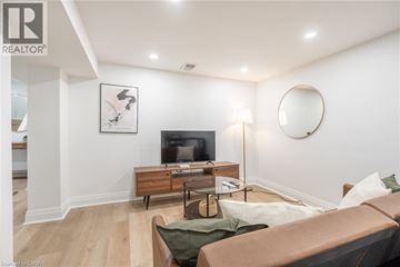 Hamilton apartment for rent - A living room with a brown couch and a wooden entertainment center.