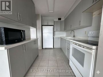 Toronto (Henry Farm) condo for rent - A kitchen with white appliances and grey cabinets.