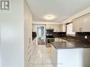Ajax (Central) multi-family for rent - A kitchen with black countertops and white cabinets.