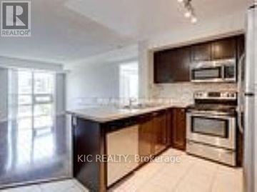 Toronto (Islington-City Centre West) condo for rent - A modern kitchen with stainless steel appliances and wooden cabinets.