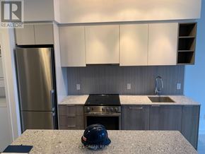 Toronto (Clanton Park) condo for rent - A kitchen with a stainless steel refrigerator and a black helmet on the counter.