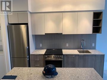 Toronto (Clanton Park) condo for rent - A kitchen with a stainless steel refrigerator and a black helmet on the counter.