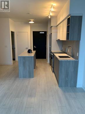 Toronto (Clanton Park) condo for rent - A kitchen with a black door and a white countertop.
