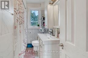 Oakville (Co Central) apartment for rent - A white bathroom with a toilet, sink, and a window.