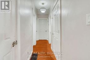 Oakville (Co Central) apartment for rent - A hallway with white doors and a wooden staircase.
