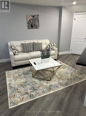 Oakville (Go Glenorchy) apartment for rent - A bedroom with a bed, wooden flooring, and a mirror.