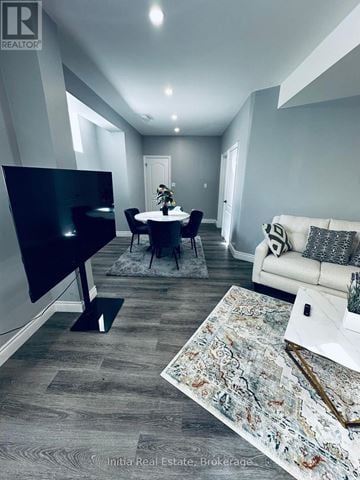 Oakville (Go Glenorchy) apartment for rent - A living room with a black television and a grey sofa.