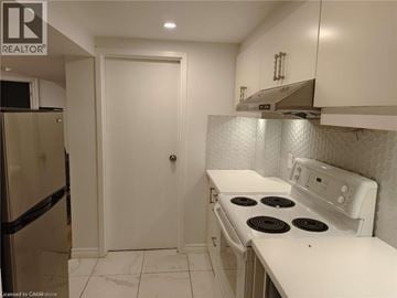 Oakville apartment for rent - A kitchen with a white stove and a white door.