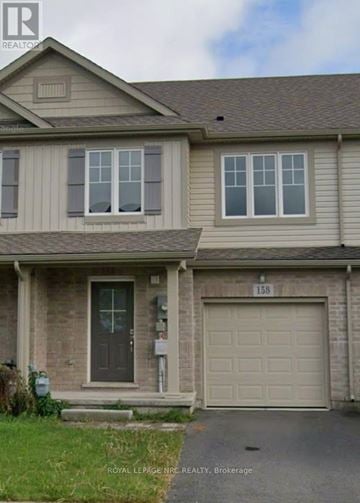 Welland (Coyle Creek) townhouse for rent - A two-story house with a garage door and a mailbox on the front door.