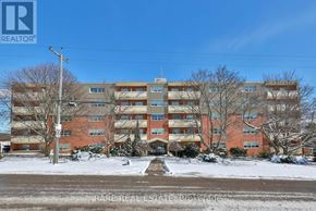 Port Hope condo for rent - A large apartment complex with a clear blue sky above.