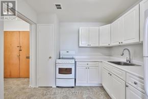 Port Hope condo for rent - A kitchen with white cabinets and a white oven.