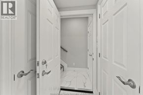 Windsor apartment for rent - A hallway with white doors and a marble floor.