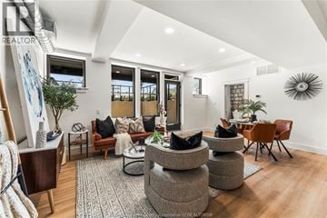Amherstburg condo for rent - A living room with a grey rug and a brown chair.