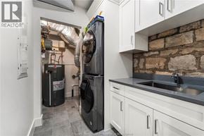 Amherstburg condo for rent - A kitchen with a black fridge and a stone wall.
