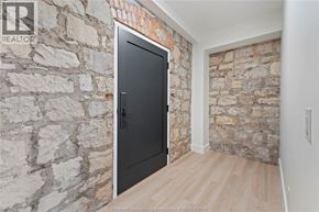 Amherstburg condo for rent - A black door is in a room with a stone wall.