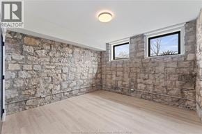 Amherstburg condo for rent - A room with stone walls and wooden flooring.