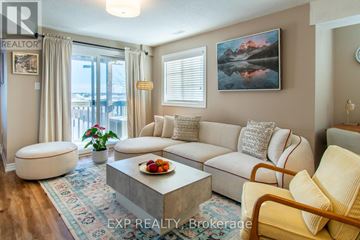 Barrie (Painswick South) townhouse for rent - A living room with a large couch, a coffee table, and a painting on the wall.