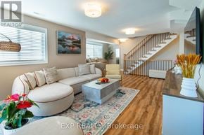 Barrie (Painswick South) townhouse for rent - A living room with a white couch and a staircase in the background.