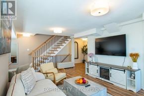 Barrie (Painswick South) townhouse for rent - A living room with a staircase and a television.