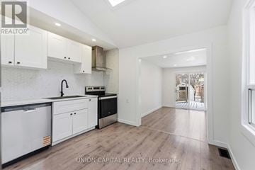 Hamilton (Stipley) apartment for rent - A kitchen with white cabinets and a black fridge.