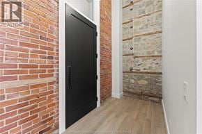 Amherstburg condo for rent - A black door is in a room with a brick wall.