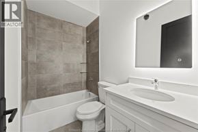 Amherstburg condo for rent - A bathroom with a toilet, sink, and tub.
