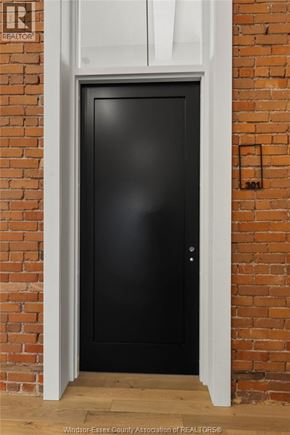 Amherstburg condo for rent - A black door is set in a brick wall.