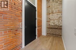 Amherstburg condo for rent - A black door is in a room with a brick wall.