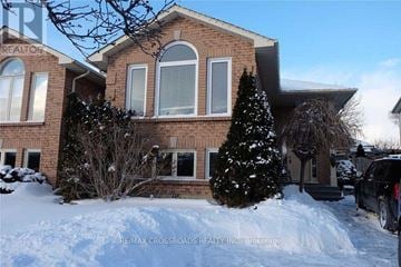 Oshawa (Pinecrest) apartment for rent - A house with a sign that says RE/MAX CROSSROADS REALTY INC. on the front.