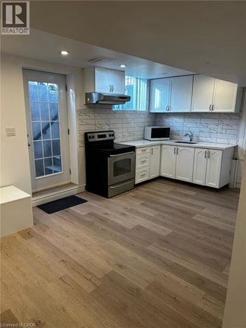 Clarington apartment for rent - A kitchen with a black stove top oven and white cabinets.