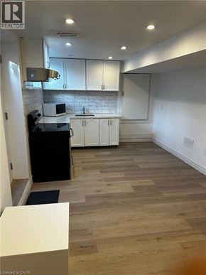 Clarington apartment for rent - A kitchen with a black stove top oven and white cabinets.