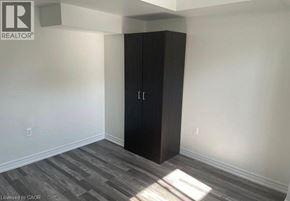 Clarington apartment for rent - A room with a black wardrobe and wooden flooring.