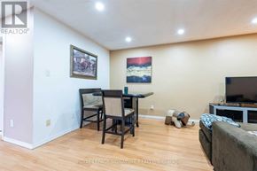Brantford apartment for rent - A living room with a couch, a chair, a dining table and a television.