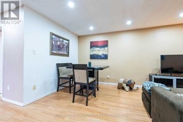 Brantford apartment for rent - A living room with a couch, a chair, a dining table and a television.