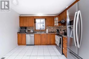 Brantford apartment for rent - A kitchen with wooden cabinets and a stainless steel refrigerator.