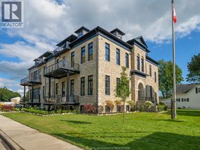 Amherstburg condo for rent - A large stone building with a balcony and a flag on a pole in front.