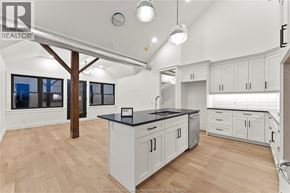 Amherstburg condo for rent - A kitchen with white cabinets and a black countertop.