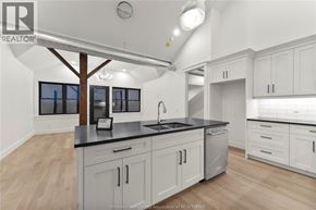 Amherstburg condo for rent - A kitchen with white cabinets and a black countertop.