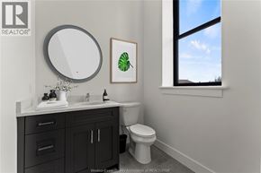 Amherstburg condo for rent - A bathroom with a toilet, sink, and a mirror.