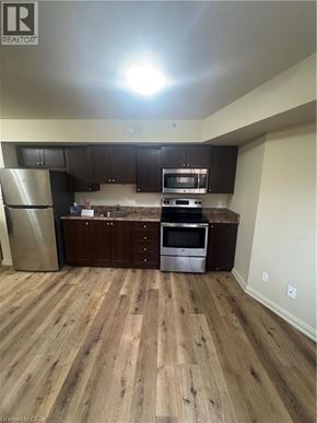 Kitchener apartment for rent - A kitchen with wooden floors and stainless steel appliances.